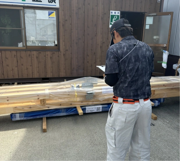 建材のそばで書類を確認するJKSの社員
